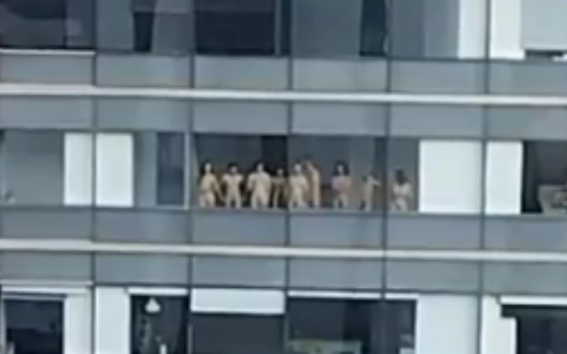 Grupo de personas se desnudan frente a ventanales en Medellín